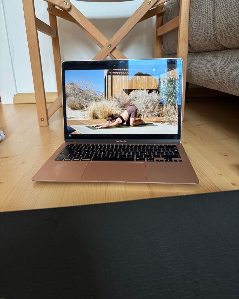 Yoga-Morgenroutine mit Laptop und YouTube-Video einer Yoga-Lehrerin