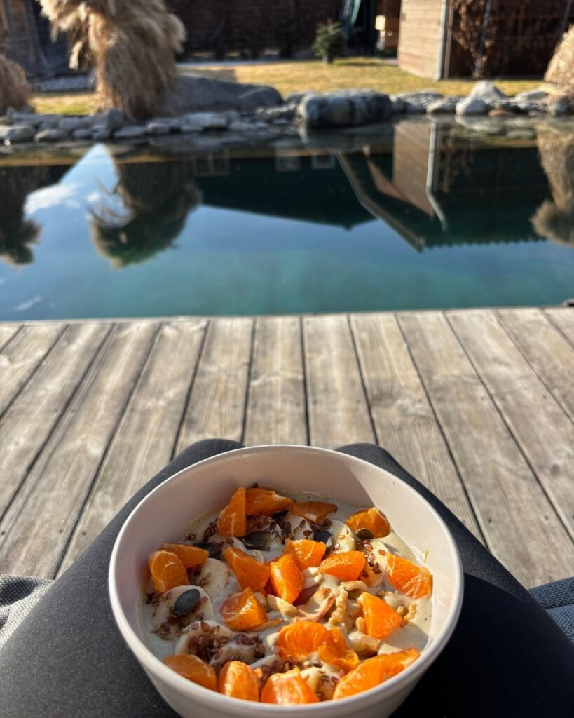 Gesundes pflanzliches Frühstück auf der Terrasse mit Blick auf einen Badeteich