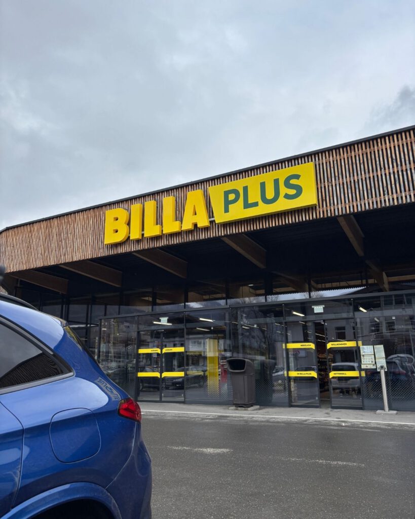 Parkplatz eines Billa Plus Supermarktes vor einer Reise