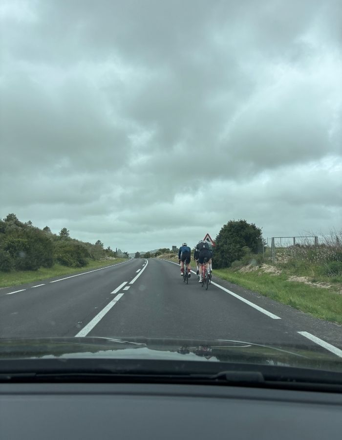 Rennradfahrer bei Regen auf der Straße auf Mallorca während einer Autofahrt